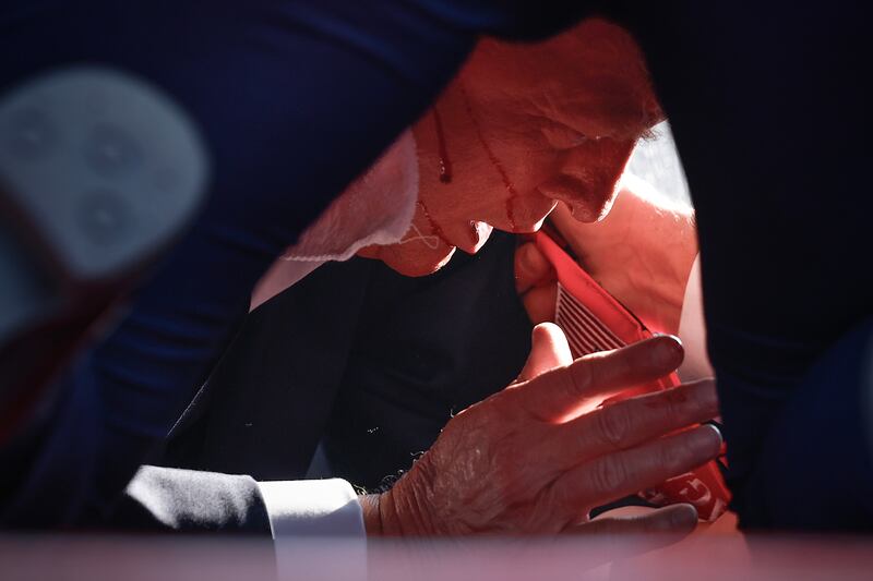 Republican presidential candidate former President Donald Trump is shown covered by U.S. Secret Service agents after an incident during a rally on July 13, 2024 in Butler, Pennsylvania