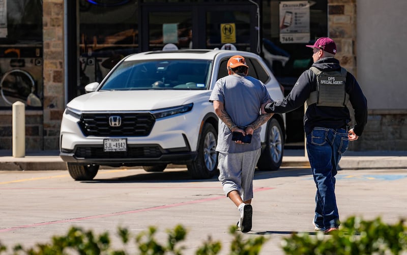 A man is detained by Federal agents as ICE conducts raids in Colony Ridge, Texas.