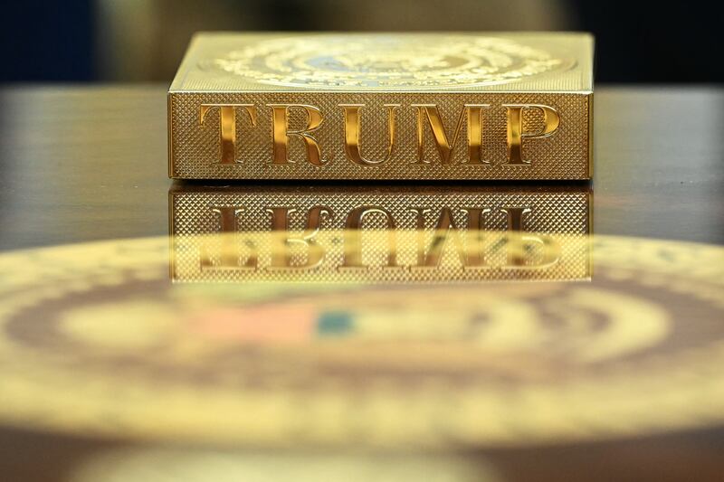 A gold coaster reading "TRUMP" sits on the table in front of US President Donald Trump as he meets with Irish Prime Minister Micheal Martin in the Oval Office of the White House in Washington, DC, on March 12, 2025.