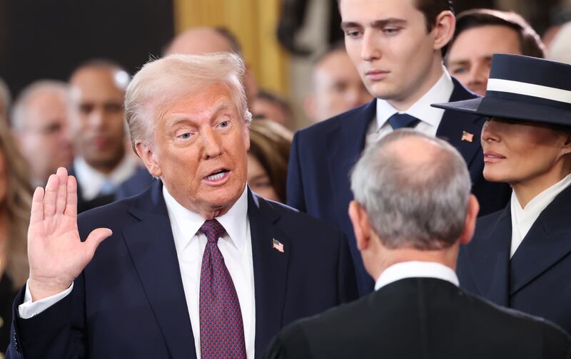 Donald Trump takes the oath of office as Barron Trump and Melania Trump look on during inauguration ceremonies in the U.S. Capitol Rotunda.
