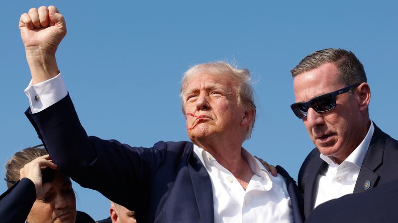 Republican presidential candidate former President Donald Trump pumps his fist as he is rushed offstage during a rally on July 13, 2024 in Butler, Pennsylvania.