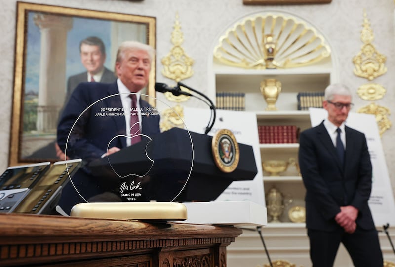 WASHINGTON, DC - AUGUST 06: U.S. President Donald Trump speaks behind an engraved glass disc presented to him by Apple CEO Tim Cook during an event in the Oval Office of the White House on August 6, 2025 in Washington, DC. Apple Inc. announced a $100 billion investment in manufacturing facilities in the U.S., on top of an announcement in February committing over the next four years to a $500 billion investment in the U.S. economy and the addition of 20,000 new jobs. (Photo by Win McNamee/Getty Images)