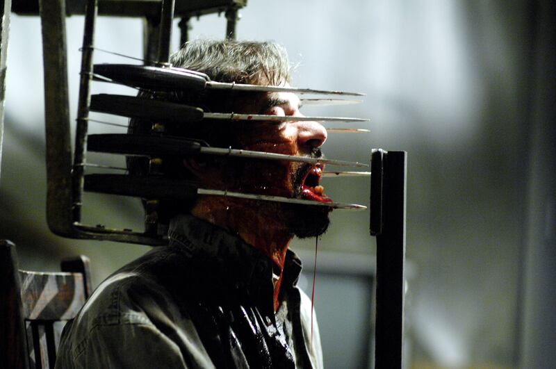A man sits in a chair made of knives