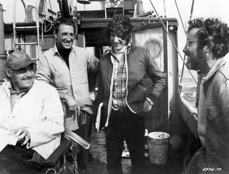 Robert Shaw, Roy Scheider, Steven Spielberg, and Richard Dreyfuss laugh together on a boat during the filming of "Jaws."