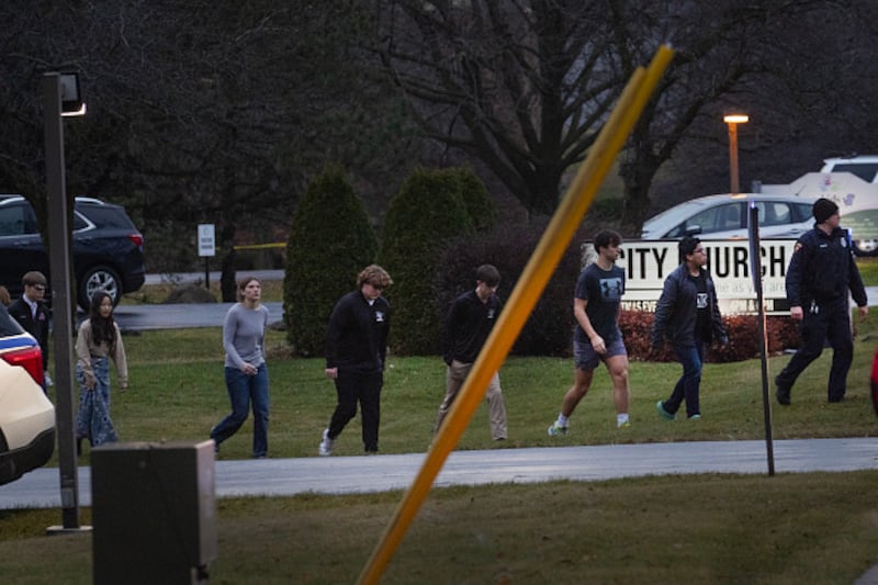 Students are escorted from a church next to the school and loaded on busses to be taken to a reunification center