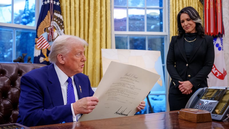 WASHINGTON, DC - FEBRUARY 12: U.S. President Donald Trump signs Tulsi Gabbard's commission for her new role as Director of National Intelligence after she was sworn in, in the Oval Office at the White House on February 12, 2025 in Washington, DC. Gabbard, who will oversee the 18 intelligence agencies and serve as Trump's advisory on intelligence, was confirmed by the Senate 52-48. (Photo by Andrew Harnik/Getty Images)