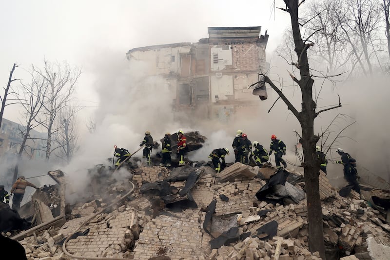 A photo of rescuers searching for people under rubble in Ukraine.