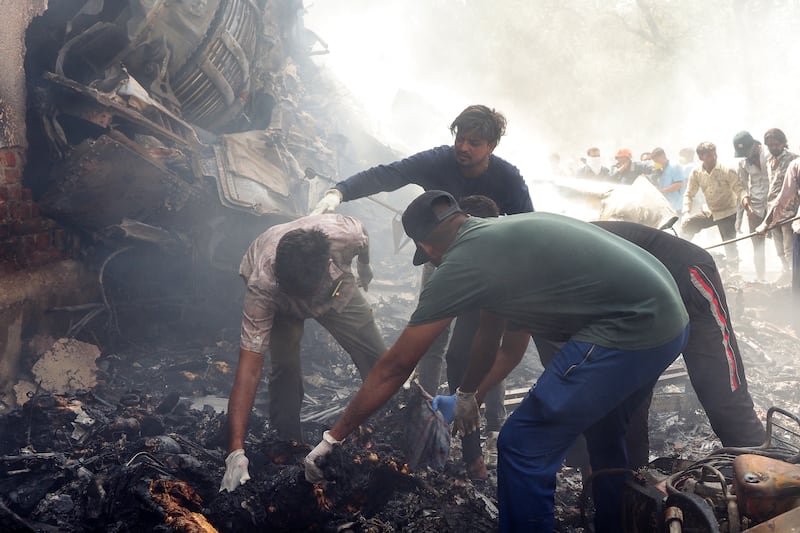TOPSHOT - Rescue officials work at the site where Air India flight 171 crashed in a residential area near the airport in Ahmedabad on June 12, 2025. The London-bound passenger plane crashed on June 12 in India's western city of Ahmedabad with 242 on board, aviation officials said in what the airline called a "tragic accident". (Photo by Sam PANTHAKY / AFP) (Photo by SAM PANTHAKY/AFP via Getty Images)