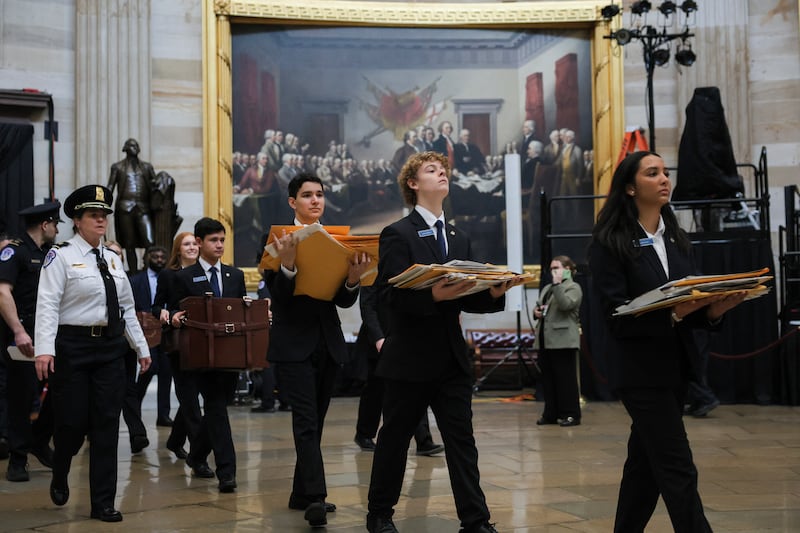 Senate pages carry electoral votes through the Rotunda after a joint session of Congress to certify the results of the 2024 presidential election on January 6, 2025, in Washington, D.C.