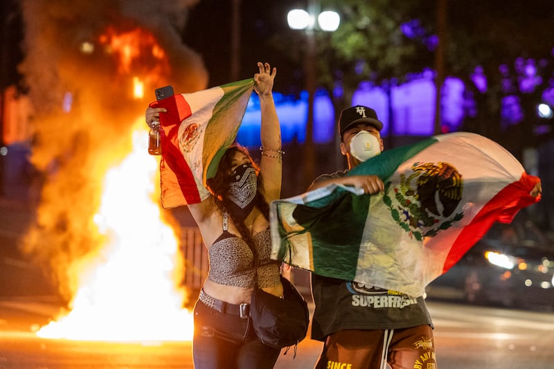 Protesters have unfurled Mexican flags amid the tense standoff with authorities.