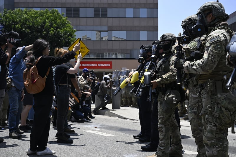 ICE officers and national guards face off with protesters outside of the Metropolitan Detention Center in Los Angeles on Sunday.