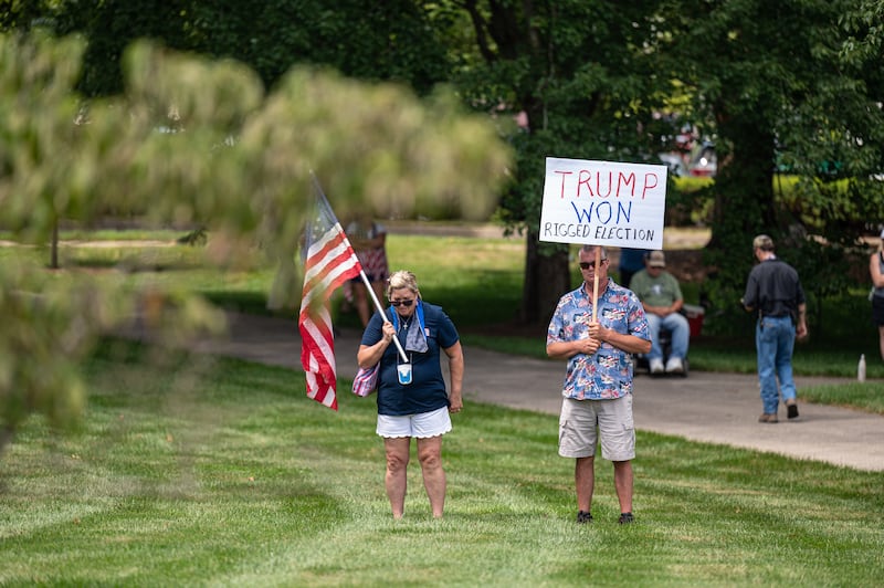 A man with a "TRUMP WON" sign listens to speakers during a rally on August 28, 2021 in Frankfort, Kentucky.