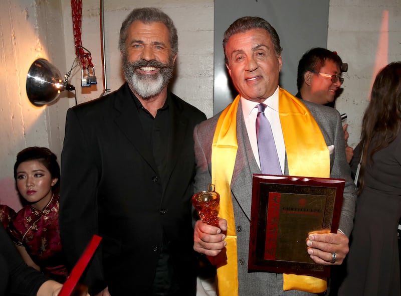 LOS ANGELES, CA - DECEMBER 15: Mel Gibson (L) and Sylvester Stallone pose backstage during the 21st Annual Huading Global Film Awards at The Theatre at Ace Hotel on December 15, 2016 in Los Angeles, California. (Photo by Christopher Polk/Getty Images)