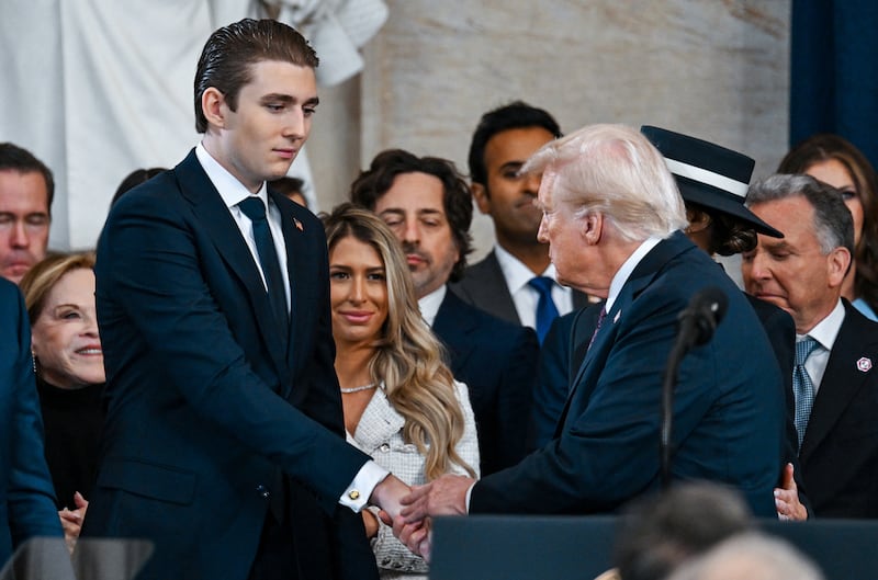 Barron Trump shakes hands with President Donald Trump.