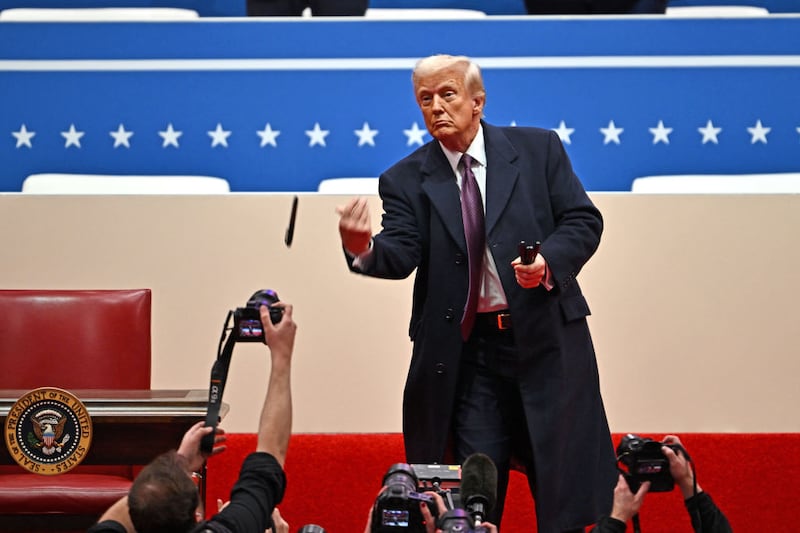 US President Donald Trump tosses sharpies to the crowd after signing executive orders.