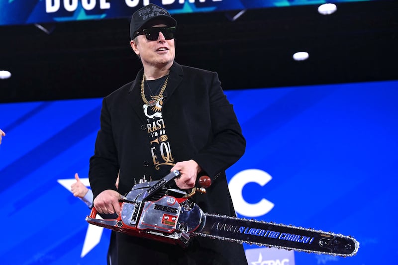 Elon Musk holds a chainsaw reading "Long live freedom, damn it" during the annual Conservative Political Action Conference (CPAC) at the Gaylord National Resort & Convention Center at National Harbor in Oxon Hill, Maryland.