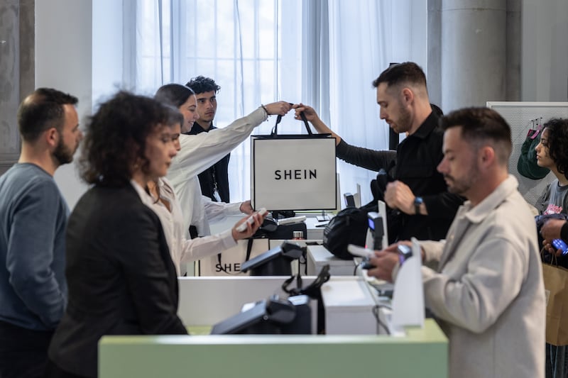 MILAN, ITALY - APRIL 17: A saleswoman handles a bag to a customer at the SHEIN’s “Spring Boutique” temporary store at Palazzo dei Giureconsulti on March 23, 2024 in Milan, Italy. SHEIN, a Chinese e-commerce platform specialized in ultra fast fashion, frequently holds temporary "pop-up" stores to allow customers to experience their products in person and to interact with the brand offline. (Photo by Emanuele Cremaschi/Getty Images)