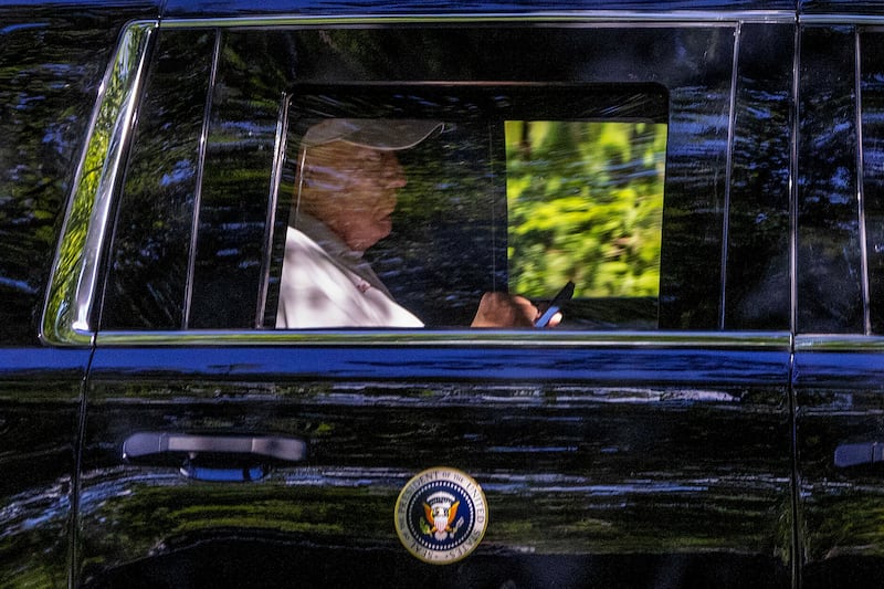 President Donald Trump checks his phone on August 31, 2025 in Washington, DC. President Trump spent the day at Trump National Golf Club during the labor day weekend.