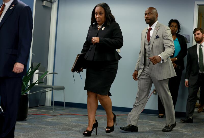 Fulton County District Attorney Fani Willis, trailed by special prosecutor Nathan Wade, arrives at a news conference in August.