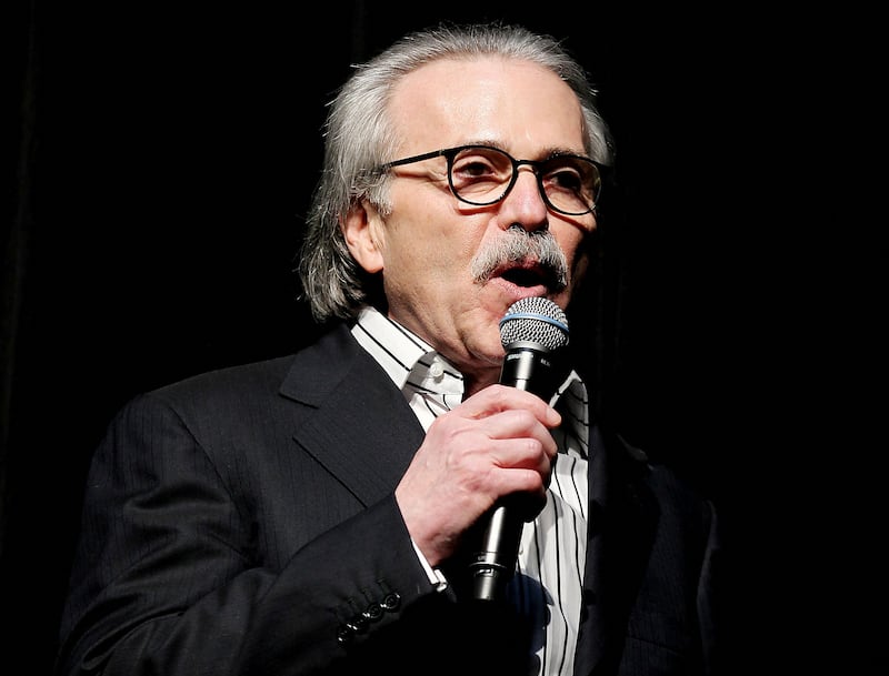 David Pecker holds a microphone while speaking on stage.