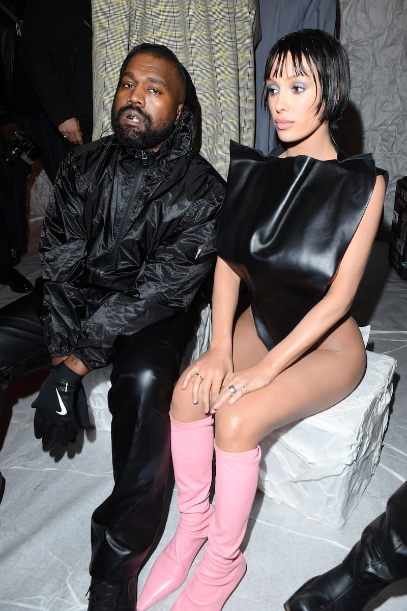 Kaney West and Bianca Censori sit at a fashion week show.