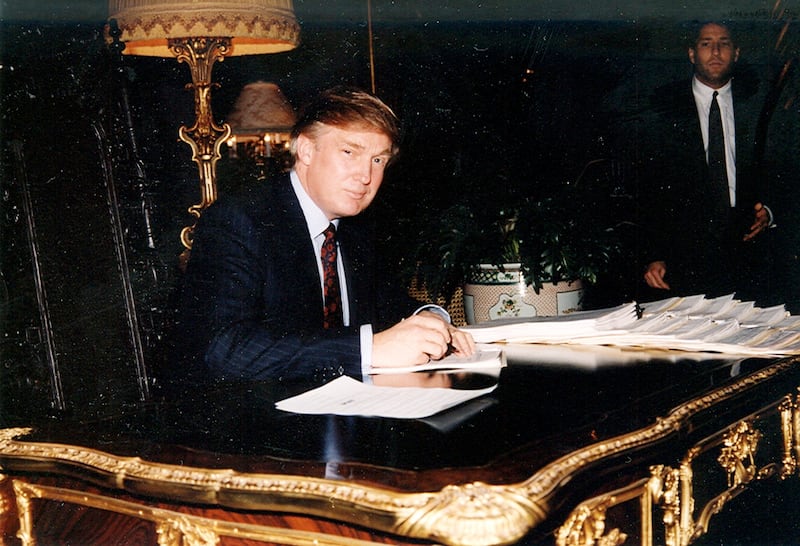 Donald Trump signs documents at a desk in the Mar-a-Lago estate, Palm Beach, Florida in 1995.