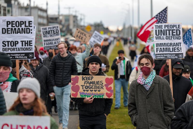 People hold signs during a march against Immigration and Customs Enforcement (ICE) entitled "Get our Gente Out of Guantanamo Bay!" in Seattle in February.