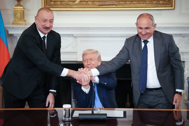 WASHINGTON, DC - AUGUST 08: U.S. President Donald Trump (C) joins hands with Azerbaijani President Ilham Aliyev (L), and Armenian Prime Minister Nikol Pashinyan (R) during a signing ceremony in the State Dining Room of the White House on August 8, 2025 in Washington, DC. The signed agreement is intended to bring an end to the conflict between Armenia and Azerbaijani that has lasted for decades. (Photo by Andrew Harnik/Getty Images)