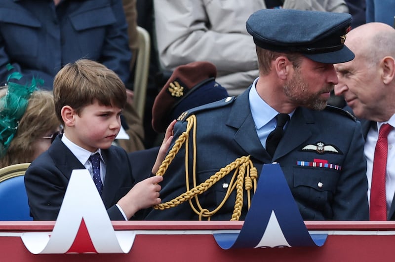 Prince William, Prince of Wales and Prince Louis watch a military procession marking the 80th anniversary of VE Day