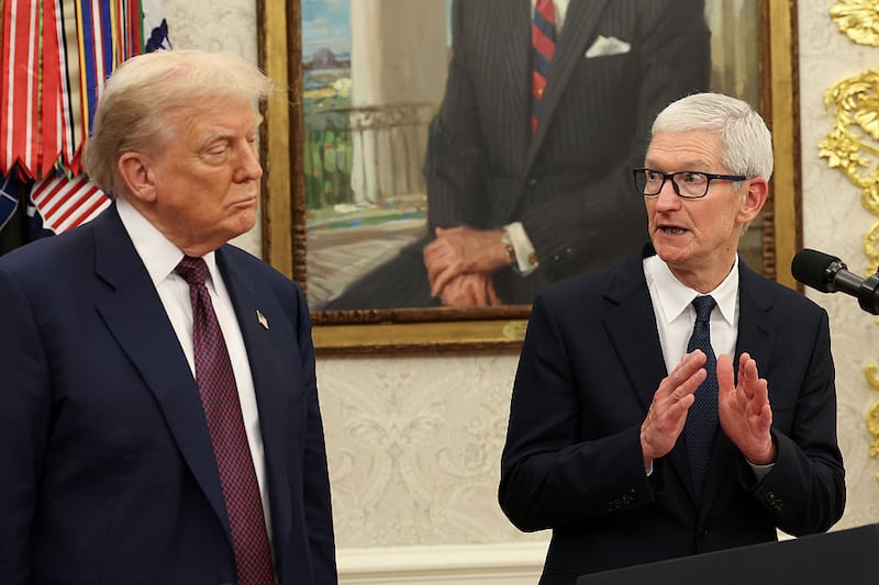 WASHINGTON, DC - AUGUST 06: Apple CEO Tim Cook (R) speaks as U.S. President Donald Trump looks on during an event in the Oval Office of the White House on August 6, 2025 in Washington, DC. Apple Inc. announced a $100 billion investment in manufacturing facilities in the U.S., on top of an announcement in February committing over the next four years to a $500 billion investment in the U.S. economy and the addition of 20,000 new jobs. (Photo by Win McNamee/Getty Images)