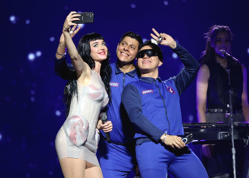 Katy Perry takes a selfie with fans onstage during the "Lifetimes" tour in Mexico City.