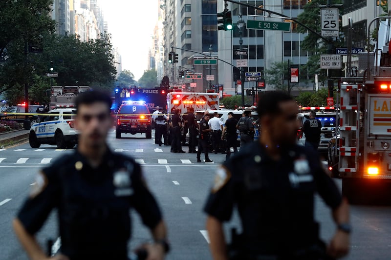 Police officers and emergency vehicles are seen in a street as police respond to a shooting incident in Midtown Manhattan on July 28, 2025.