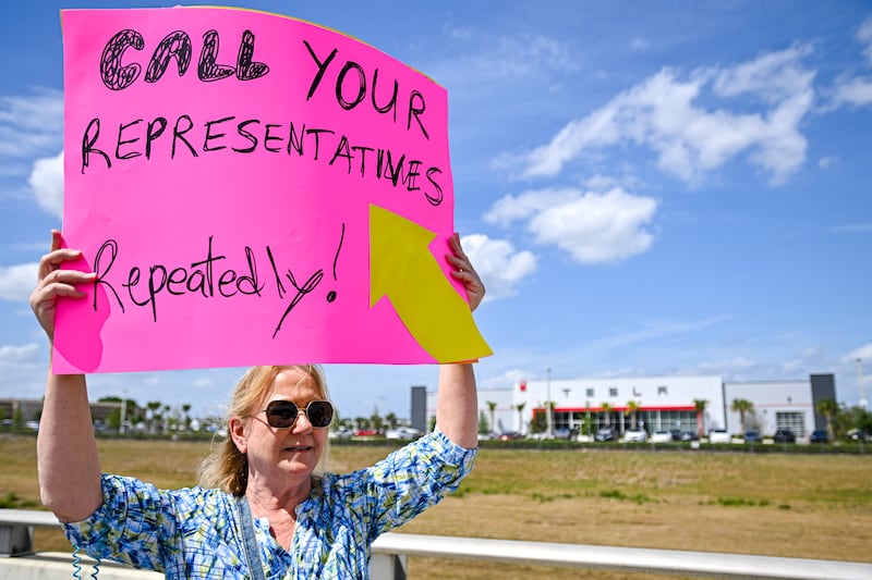 Demonstrators rally against Elon Musk during a "Tesla Takedown" protest outside a Tesla dealership in Clermont, Florida, on March 29, 2025.