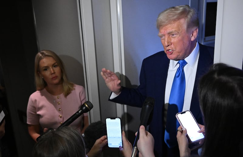 Donald Trump engages with members of the White House press pool on Air Force One.