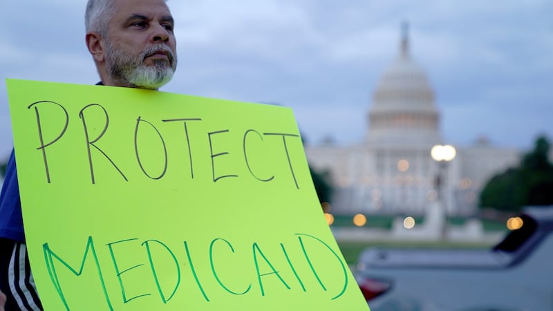 A protestor holds a sign reading "protect Medicaid" outside the U.S. Capitol in Washington, DC.