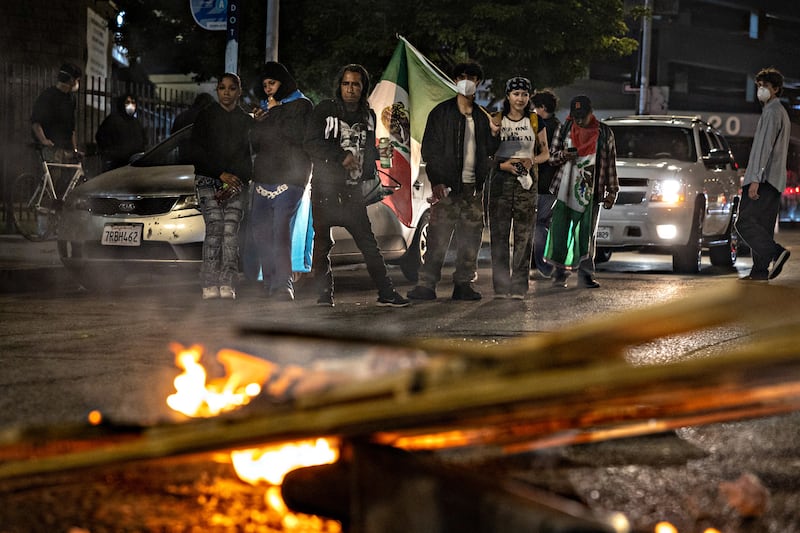 Demonstrators gather around a fire that was set on San Pedro street as protesters continue to clash with the Los Angeles Police Department in downtown Los Angeles due to the immigration raids in L.A. on Monday, June 9, 2025.