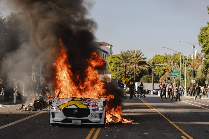 Several cars burn on North Los Angeles street during clashes between protesters and police on June 8, 2025 in Downtown Los Angeles, California.