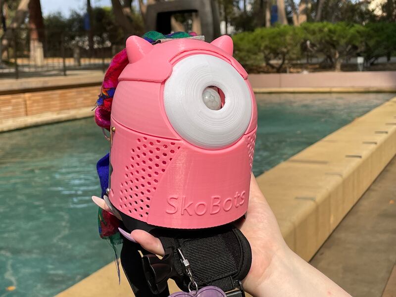SkoBot inventor Danielle Boyer wears one of her customizable language-teaching devices strapped to her shoulder.