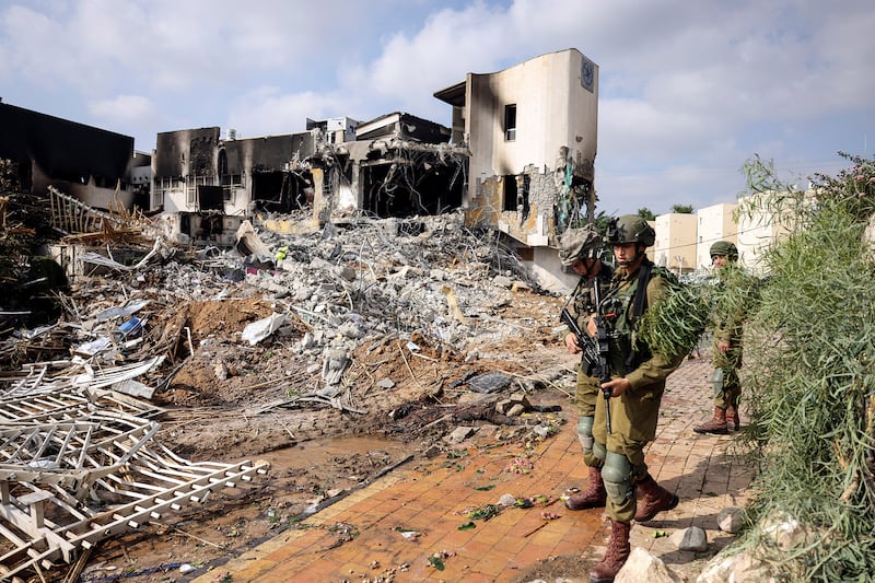 Israeli soldiers patrol outside a police station which was the site of a battle following a mass infiltration by Hamas.