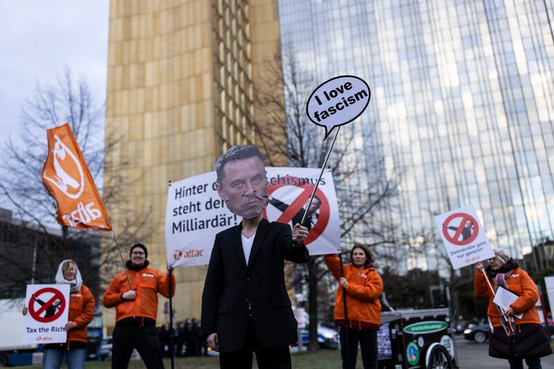 Protesters outside the WELT Economy Summit hold up a placards criticizing tech billionaire Elon Musk on January 27, 2025 in Berlin, Germany.