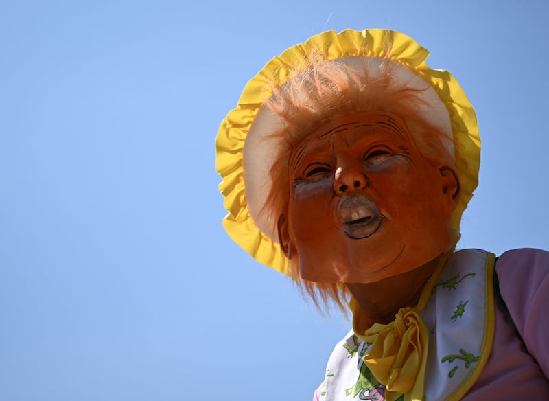 A protester dressed as a baby wears a mask depicting President Donald Trump during a rally in Washington, D.C. on May 1, 2025.