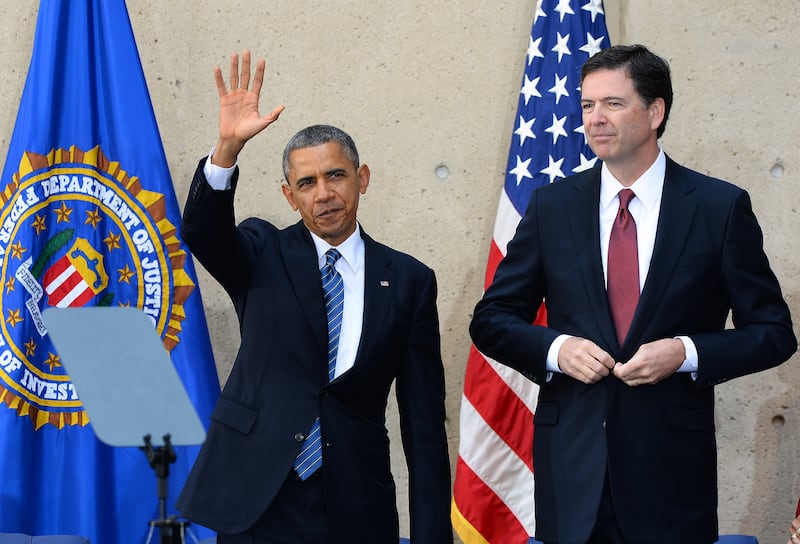 US President Barack Obama (L) waves as new Federal Bureau of Investigation (FBI) director James Comey looks on after an installation ceremony at the FBI headquarters in Washington, DC, on October 28, 2013. Comey was a top Justice Department official in the Bush administration and took over last month for Robert Mueller, who stepped down after 12 years of heading the agency. AFP Photo/Jewel Samad (Photo credit should read JEWEL SAMAD/AFP via Getty Images)