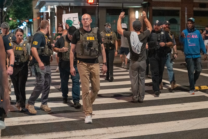 WASHINGTON, DC - AUGUST 13: FBI agents are followed by protesters in the U street neighborhood on August 13, 2025 in Washington, DC. U.S. President Donald Trump announced plans to deploy federal officers and the National Guard to the District in order to place the DC Metropolitan Police Department under federal control and assist in crime prevention in the nation's capital. (Photo by Andrew Leyden/Getty Images)