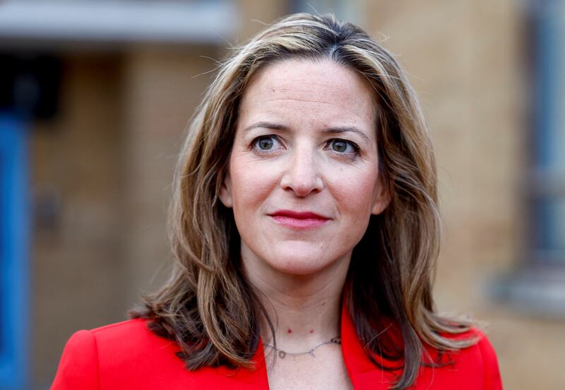 Michigan Secretary of State, Jocelyn Benson, wearing a red dress, speaks to reporters on midterm election day in 2022.
