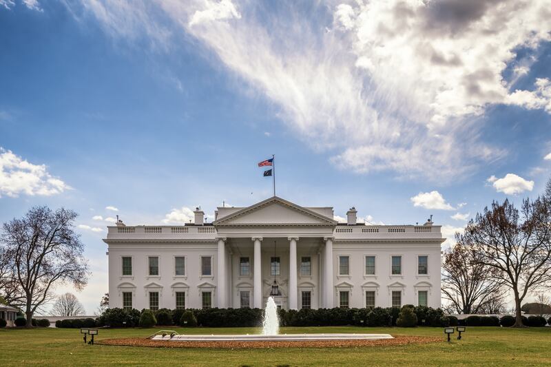An American flag and a POW-MIA flag fly atop the White House in March. President Donald Trump says he will pay out of pocket to have two 100-foot flagpoles installed on the north and south White House lawns.