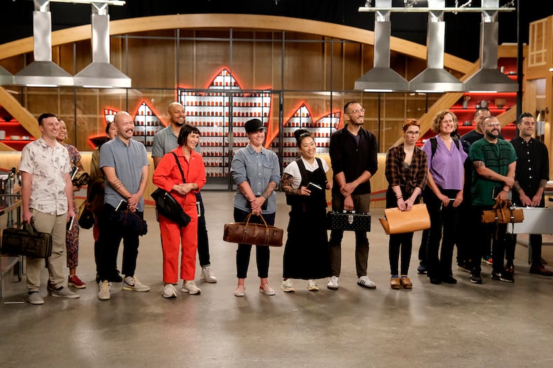 Vincenzo Loseto, Lana Lagomarsini, Shuai Wang, Corwin Hemming, Kat Turner, Mimi Weissenborn, Katianna Hong, Cesar Murilo, Bailey Sullivan, Anya El-Wattar, Zubair Mohajirl, and Massimo Piedimonte standing in a line during an episode of Top Chef Season 22.