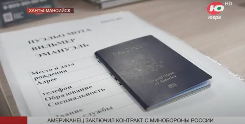 A view of paperwork showing the name Wilmer Emanuel Puello-Mota alongside an American passport.