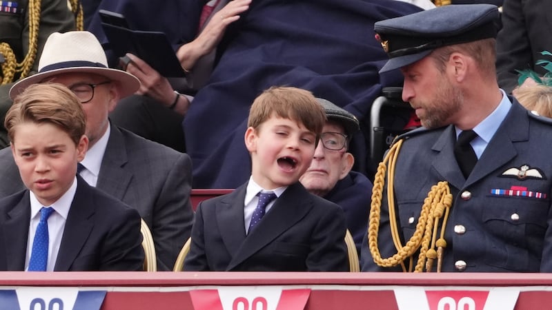 Prince Louis shares a joke with his dad, the Prince of Wales, while his brother Prince George looks on. They were watching the military procession for the 80th anniversary of VE Day, at Buckingham Palace in central London.
