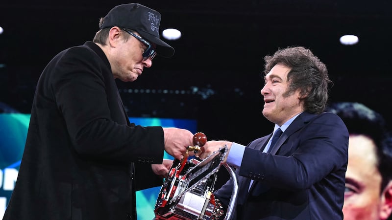 Elon Musk (L) holds a chainsaw with Argentine President Javier Milei during the annual Conservative Political Action Conference (CPAC) at the Gaylord National Resort & Convention Center at National Harbor in Oxon Hill, Maryland, on February 20, 2025. The chainsaw was a present to Elon Musk from Argentina's President Javier Milei. (Photo by SAUL LOEB / AFP) (Photo by SAUL LOEB/AFP via Getty Images)