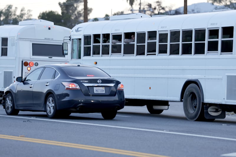 A couple of marines look out the window during a convoy in white buses head to Los Angeles on Hwy. 62 outside Yucca Valley, CA on Monday, June, 2025.